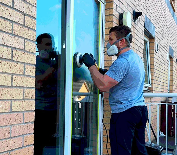 Professional glass technician restoring scratched glass surface